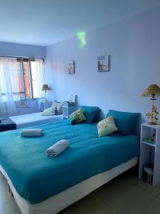 - une chambre bleue avec 2 lits et des oreillers dans l'établissement Le Palace climatisé au centre-ville - Piscine - Proximité Plage et Espagne, à Perpignan