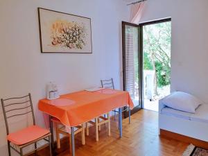 a dining room with an orange table and chairs at Apartments Brebric in Šilo