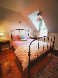 a bedroom with a bed and a window at Orchard Cottage in Dingle