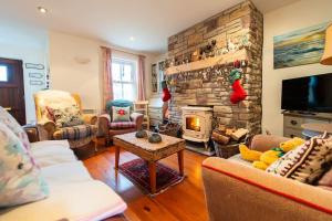 a living room with a fireplace and a stone wall at Orchard Cottage in Dingle