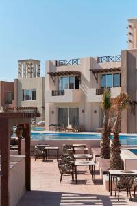 a resort with a swimming pool and tables and chairs at True Beach Resort in Marsa Alam City