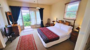a bedroom with a bed and a television and windows at Leura House in Leura