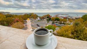 una tazza di caffè seduta su un piatto su un cornicione di Tekirdağ Yat Hotel a Tekirdağ
