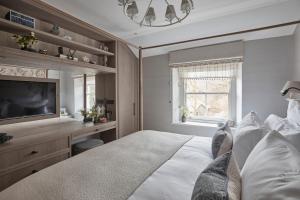 a bedroom with a bed and a flat screen tv at The Little Cottage in Chapel Stile