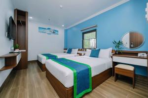 Pokój hotelowy z 2 łóżkami i biurkiem w obiekcie TOMMY HOTEL w mieście Cát Bà