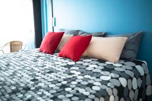 ein Bett mit roten und weißen Kissen darauf in der Unterkunft Beach Apartment in Faro