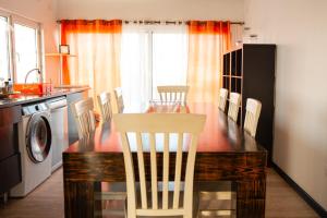 a kitchen with a table and chairs and a dining room at Beach Apartment in Faro