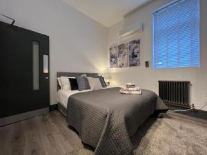 1 dormitorio con cama y ventana en Grand Prix House, en Londres