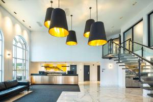 a lobby with a staircase and several lights at Les Suites de Laviolette Ascend Hotel Collection in Trois-Rivières