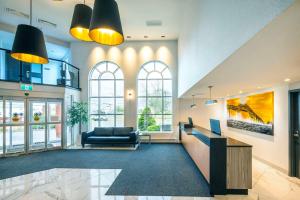 a lobby with a couch and a desk and windows at Les Suites de Laviolette Ascend Hotel Collection in Trois-Rivières