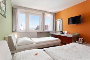 オパヴァにあるHotel Korunaのベッド2台とテレビが備わるホテルルームです。