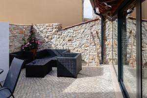 un patio con banco y pared de piedra en Casa das Libras - Recantos d'Almerinda 