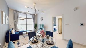 uma sala de estar com uma mesa e cadeiras azuis em Primestay - Prime Views 1BR - Meydan em Dubai