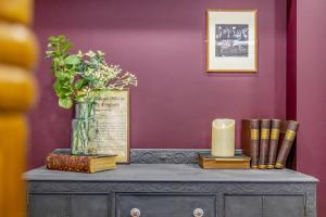 a table with a vase with a candle and books at The Rooftops in Boston