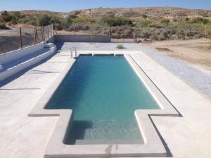 une piscine au milieu d'un désert dans l'établissement Cuevas Alcobas, à Baza