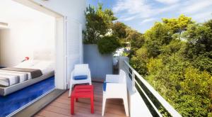 a balcony with a bed and a red chair at Hotel della baia - Negombo Parco Termale in Lacco Ameno +30 photos