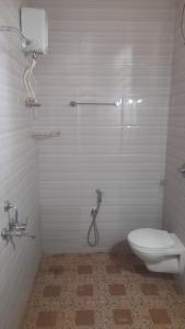 a bathroom with a shower and a toilet in it at INAS Guest House in Canacona
