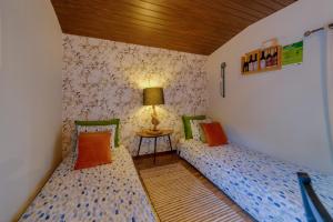 een kamer met 2 bedden en een tafel met een lamp bij Arrabia Casa da Eira in Raiva