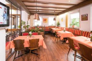 オーベルストドルフにあるホテル ガルニ レジーナのテーブルと椅子が備わるレストラン