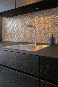 uma cozinha com um lavatório e uma parede em mosaico em Pastoria Residence em Maastricht