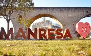 Ein Schild, auf dem Manisnesia vor einem Gebäude steht. in der Unterkunft Habitació polivalent al centre de Manresa in Manresa