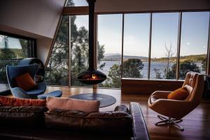 WoodbridgeにあるApollo Bay Houseのソファと暖炉のあるリビングルーム