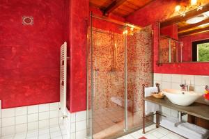 baño rojo con lavabo y ducha en Kallikoros Country Resort & Spa, en Noto