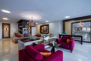 sala de estar con sillas moradas y sofá en Palmeras Beach Hotel Ultra All Inclusive, en Konaklı