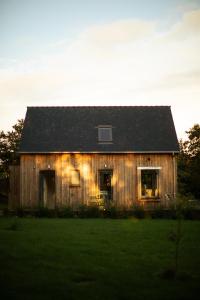 uma casa de madeira com um telhado preto em Douarenn em Berrien