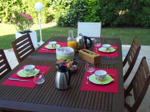- une table en bois avec des serviettes rouges et de la nourriture dans l'établissement Les Hautes Marnes Proche circuit, à Saint-Gervais en-Belin