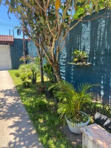 un giardino con piante e panca accanto a un muro di Casa com Piscina Bertioga a Bertioga