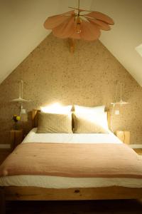 - une chambre avec un grand lit et un ventilateur de plafond dans l'établissement Douarenn, à Berrien