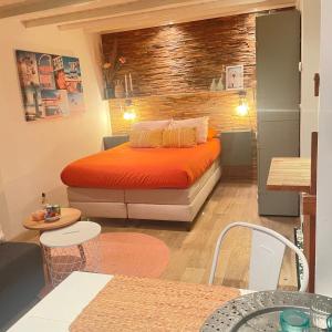 エグモント・アーン・ゼーにあるKust 2のベッドルーム1室(オレンジ色のベッドカバー付)
