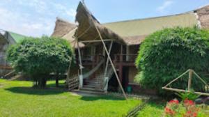 una casa con una scala di fronte a un cortile di Dekasang Majuli a Majuli