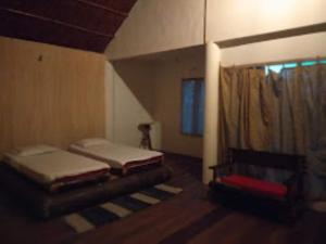 1 dormitorio con 2 camas y ventana en Dekasang Majuli, en Majuli