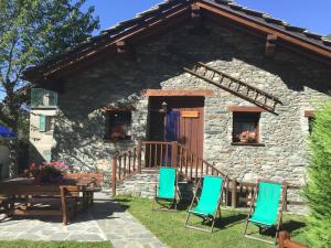 a stone house with chairs and a wooden door at Casevacanza Val d'Ayas in Challand Saint Anselme