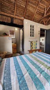 Lakeside Paradise Inhambane في Ligogo: غرفة نوم بسرير لحاف ازرق وبيض
