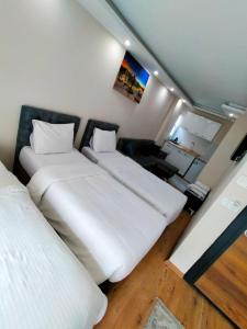 duas camas num pequeno quarto com lençóis brancos em BlueRoyal Grand Bazaar em Istambul