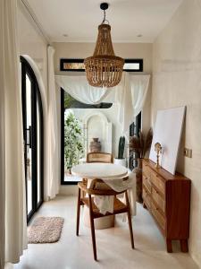 チャングーにあるNEW! Stylish Suite in the heart of Canggu - NOOCA BALIのテーブルとシャンデリアのあるダイニングルーム
