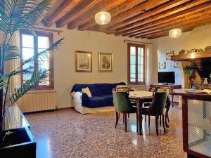 sala de estar con sofá, mesa y sillas en Ca' Nadia Apartment, en Venecia