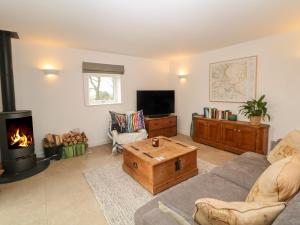 uma sala de estar com um sofá e uma lareira em Harebell Cottage em Curbar