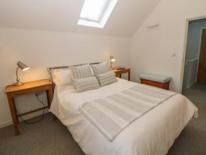 um quarto com uma cama com duas almofadas e uma janela em Harebell Cottage em Curbar