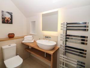 a bathroom with a white sink and a toilet at Harebell Cottage in Curbar +19 photos