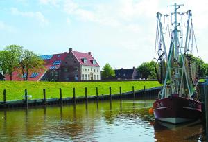 グレートジールにあるAmtmannshaus Greetsielの船が水上の桟橋に停泊