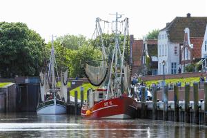 グレートジールにあるAmtmannshaus Greetsielの2隻の船が水上の桟橋に停泊