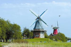 グレートジールにあるAmtmannshaus Greetsielの草の茂った丘の頂上にある2つの風車 +88枚の写真