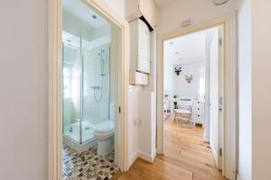 a bathroom with a toilet and a glass shower at Bond Street Apartment - Sleeps 4 in London