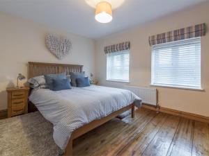 a bedroom with a large bed and two windows at 2 bed property in Mundesley Norfolk KT044 in Mundesley