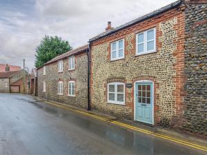 a brick building with a blue door on a street at 2 bed property in Mundesley Norfolk KT044 in Mundesley