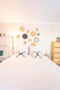 ein Schlafzimmer mit einem weißen Bett mit Platten an der Wand in der Unterkunft -Super zentrales Zimmer- direkt an der Lutter! in Bielefeld